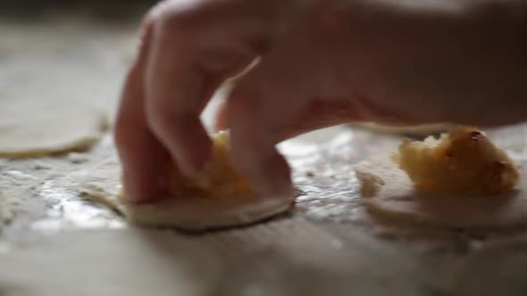 A Man Lays A Filling Of Potatoes In Dumplings For Cooking