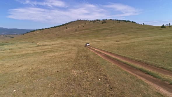 Aerial Footage Filmed with Drone of Pickup Car Riding in Steppe. the Car Travels Along the Steppe alt