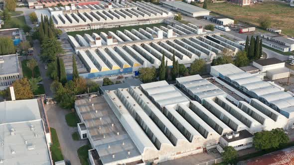 Factory buildings in an industrial park with saw-tooth roofs - business halls. alt
