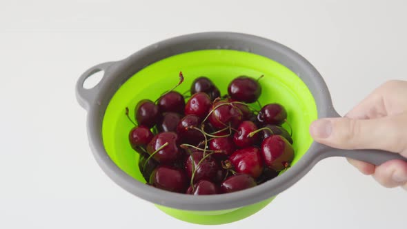 Juicy Red Refreshing Cherries a Source of Vitamins and a Healthy Lifestyle in a Green Strainer on a
