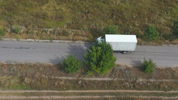 Aerial Shot of Truck with Cargo Trailer Driving on Road and Transporting Goods. Flying Over Delivery alt