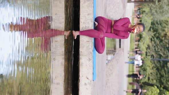 Attractive Sportive African Girl in Sportswear Resting on Yoga Mat After Training in Summer Park alt