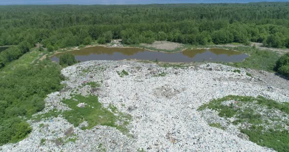 Aerial Top View of Illegal Garbage Dump in the Middle of the Green Forest alt