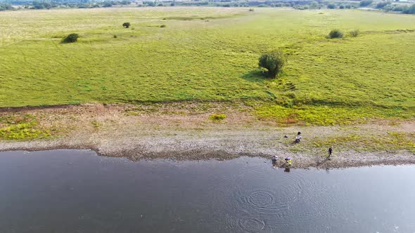 Children are Resting on the Shore of the Lake in the Village alt