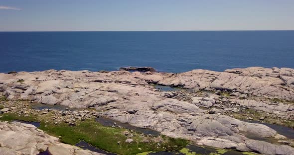 Beautiful flyover of a rocky, rugged shoreline along the Atlantic Coast in Nova Scotia, Canada on a alt