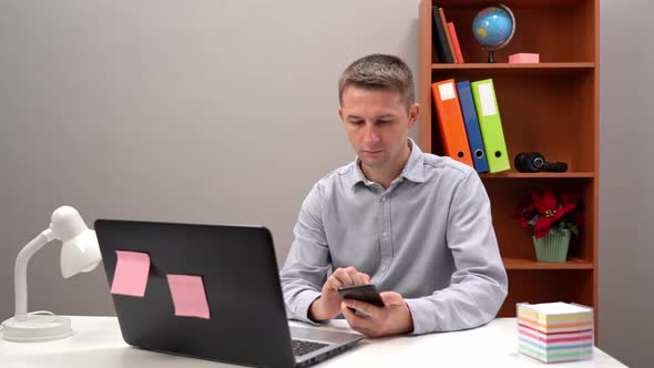 Entrepreneur Multitasking in an Office Environment By Using a Smartphone and a Laptop to Research alt