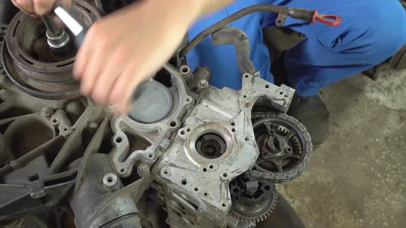 View of disassembled car engine. hands of mechanic repairing engine alt