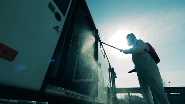 Coronavirus Prevention, Sanitary Disinfection Process. Outside View of a Bus Getting Disinfected By alt