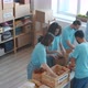 Diverse Group of Enthusiastic Volunteers Packing Donation Boxes with Food and Talking in Charity - VideoHive Item for Sale