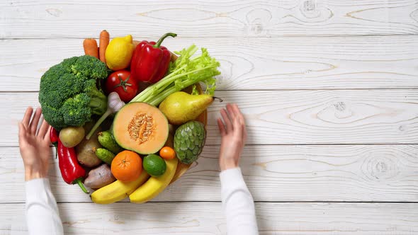 Plate with vegetables and fruits on wooden table