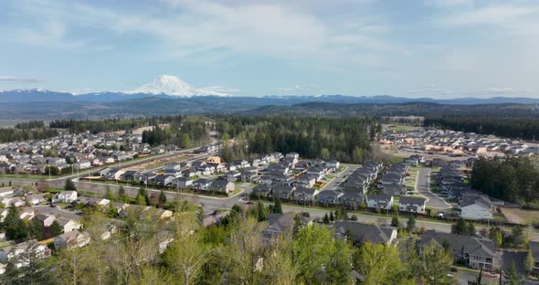 Wide aerial shot of American neighborhoods living in the shadow of Mount Rainier. alt