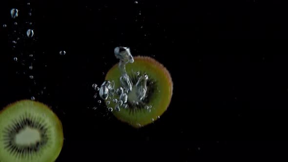 Kiwi Falling into Water Super Slowmotion, Black Background, lots of Air Bubbles, 4k240fps alt