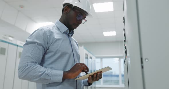 Portrait of an Engineer in a Hard Hat Holding a Tablet alt