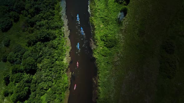 Aerial Flight Over a Group of Kayaks Floating Along the River One After Another