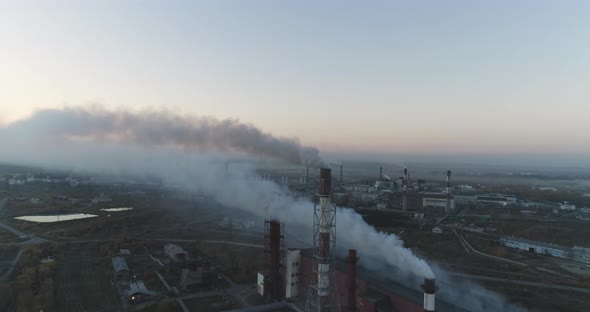 Aerial top view of steel factory. Smoking chimneys of industrial buildings. alt