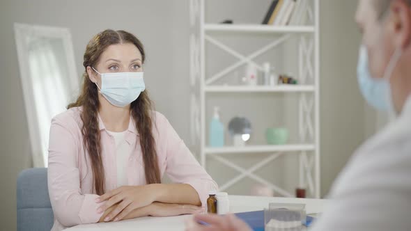 Portrait of Beautiful Woman in Face Mask Listening To Doctor in Hospital, Serious Young Caucasian alt