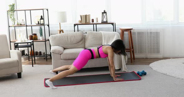 Black woman making plank flexing legs exercise.