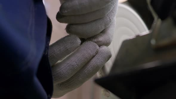 A Worker Burnishes the Finished Silver Spoon with a Machinetool at the Plant for Production Items of alt