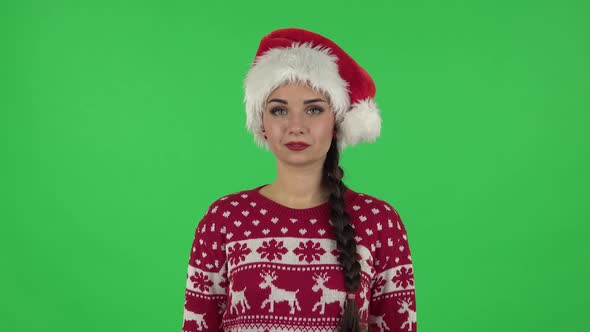 Portrait of Sweety Girl in Santa Claus Hat Is Making Sign Ok. Green Screen alt