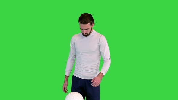 Soccer Player Holding and Playing with a Ball on a Green Screen Chroma Key