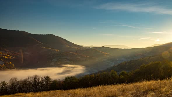 Sunset in Highland and Evening Fog Fills Valley in Autumn alt