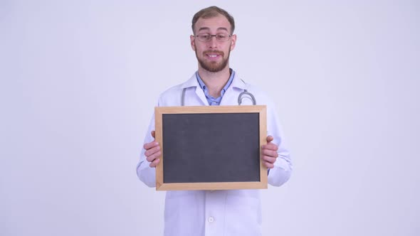 Happy Bearded Man Doctor Talking While Holding Blackboard