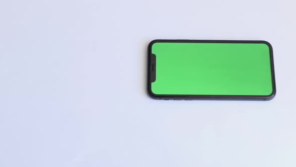 Place for Tea Drinking with Smartphone on White Table with Green Screen