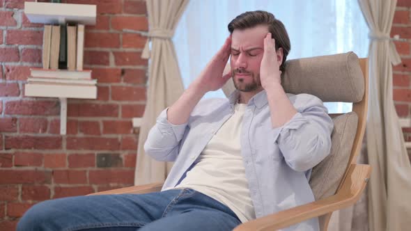 Young Man Having Headache While Sitting on Sofa alt