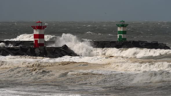 Powerful rough stormy waves crashing in promenade with lighthouse; static alt