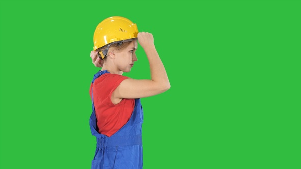 Young happy attractive woman in construction uniform putting alt