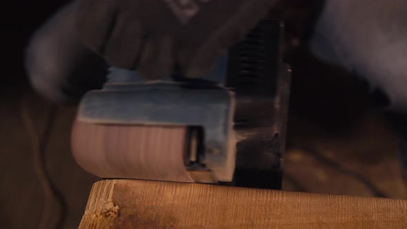 Working Buffing Electrotool Is in Hands of Worker of Factory, Touching Wood alt