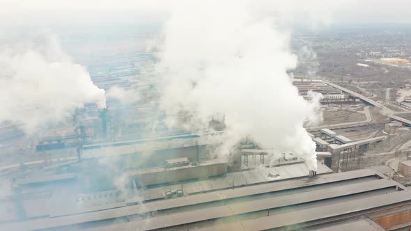 Industrial Zone with a Large Red and White Pipe Thick White Smoke Is Poured From the Factory Pipe alt