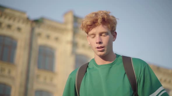 Portrait of Confident Intelligent Redhead Student at Sunset Outdoors. Young Caucasian Handsome Man alt