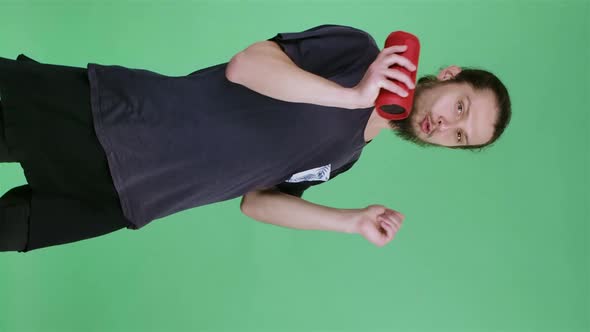 Portrait of a Man Listening to Music with a Red Portable Bluetooth Speaker Who Sings Along to the alt