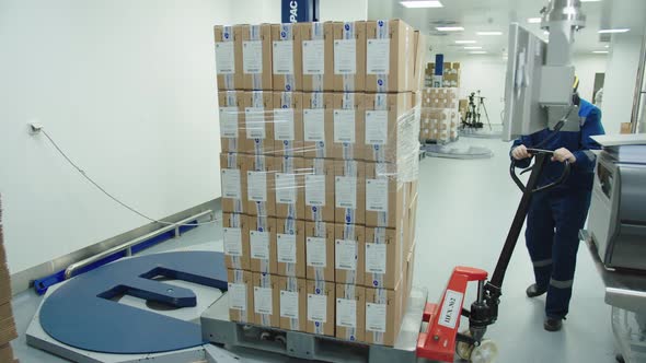 Loader in Protective Mask and Uniform Operates Manually the Cargo Trolley at the Pharmaceutical