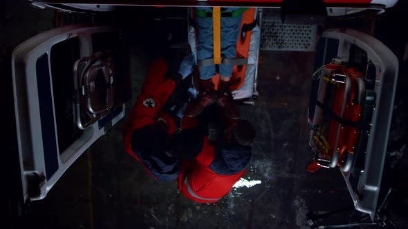 Multi Ethnic Paramedics Moving Injured Man on Stretchers in Emergency Car alt