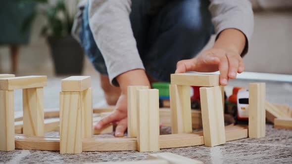 Child Play Build Wooden Railroad Starts an Electronic Steam Locomotive Sitting on the Floor at Home