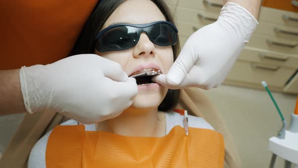 Doctor Dentist Makes Makes an Impression of the Teeth of a Female Patient alt