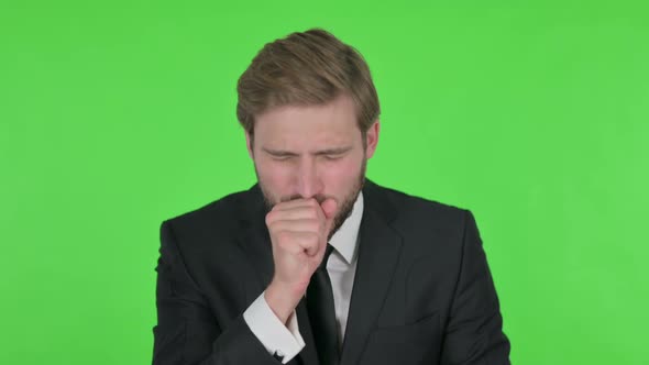 Young Businessman Coughing on Green Background alt