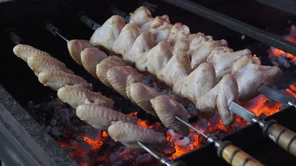 Chicken Wings on Skewers Is Cooked on Barbecue at Street Food Festival
