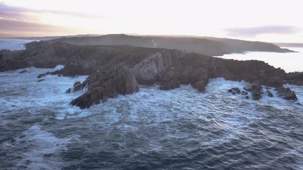 Aerial over a rocky coastline with waves breaking