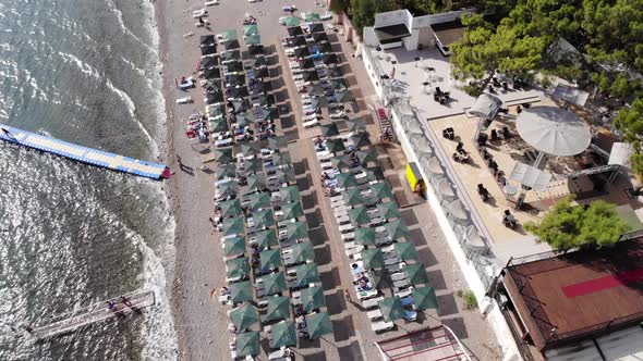 Top View of Rows of Sun Loungers By the Sea in a Recreation Area with Tourists and a Floating Pier alt
