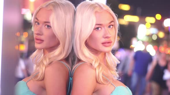 Sexy Blonde Girl in Exterior of Shiny Colorful Las Vegas Leaning on Window alt