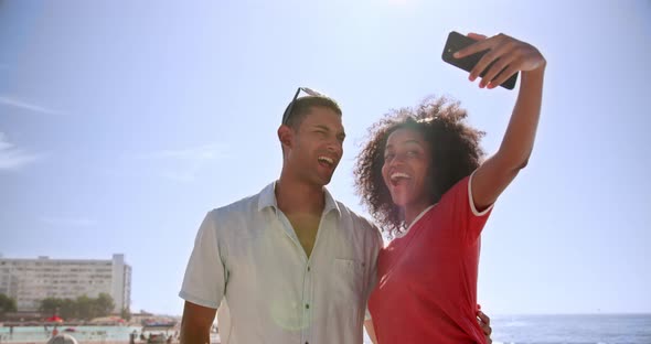 Couple taking selfie with mobile phone at beach promenade 4k