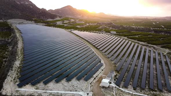 Solar panels farm aerial view from drone shot while sun setting. Small photovoltaic cell panels alt