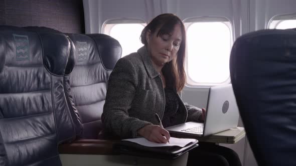 Businesswoman using laptop computer on airplane