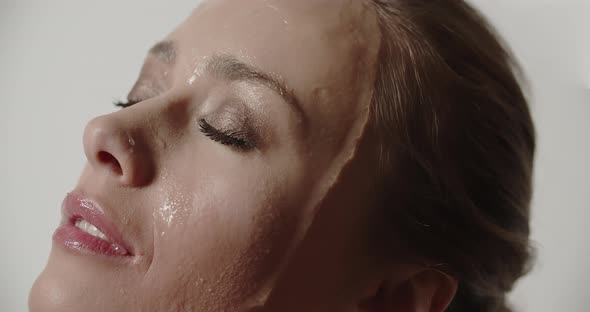 Sensuous Woman With Eyes Closed As Water Pours Over Her Face