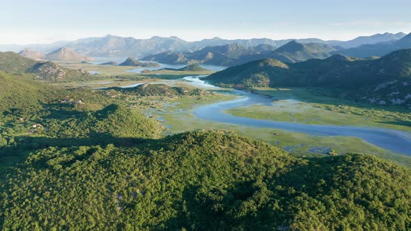 River meandering through the valley toward distant mountains, in the morning alt