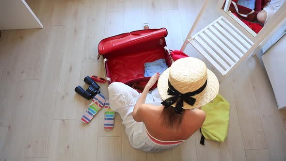 Young girl preparing for vacation. Pack up clothes in suitcase at home. alt