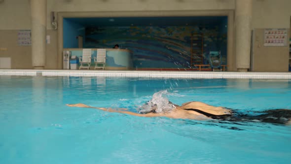 Woman in Black Swimsuit Swims Crawl in the Pool